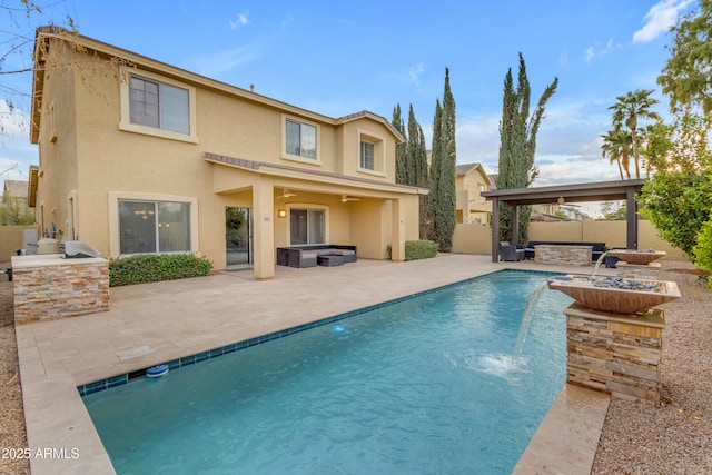 rear view of property with stucco siding, a fire pit, an outdoor pool, area for grilling, and a fenced backyard