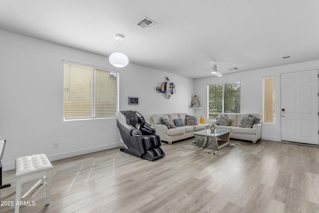 living area featuring light wood-style floors, visible vents, and baseboards