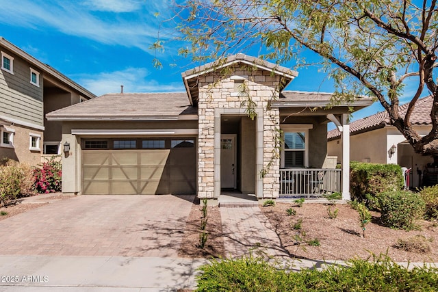 view of front facade with decorative driveway, stucco siding, a porch, a garage, and stone siding