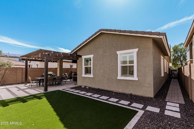 back of property with a patio, a fenced backyard, a yard, a pergola, and stucco siding