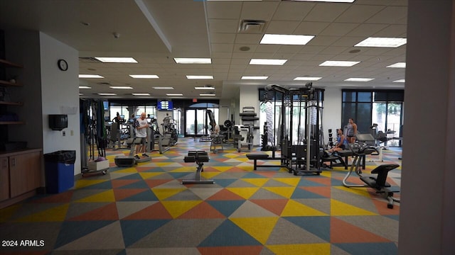 workout area with a drop ceiling and carpet flooring