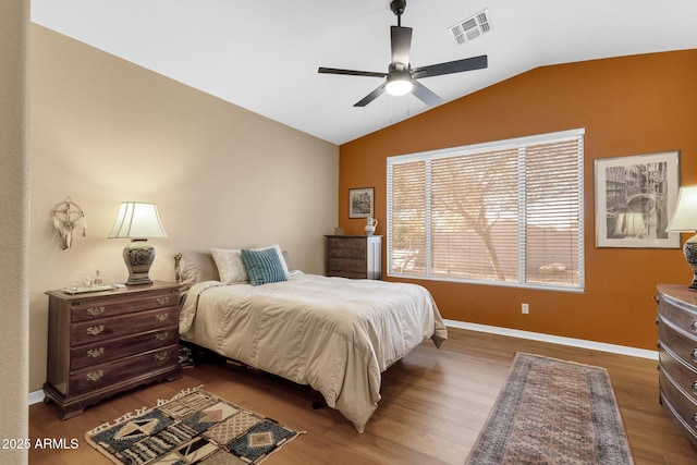 bedroom with ceiling fan, lofted ceiling, and dark hardwood / wood-style floors