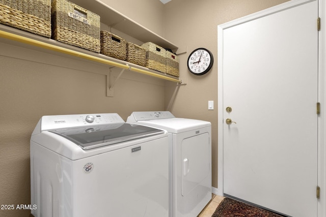 washroom featuring washer and clothes dryer and light tile patterned floors