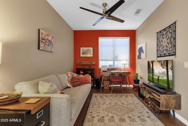 living room featuring dark wood-type flooring and ceiling fan