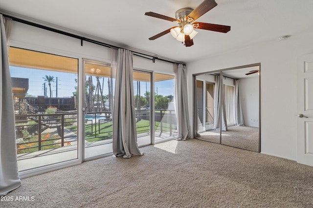 interior space with ceiling fan, carpet floors, and access to outside