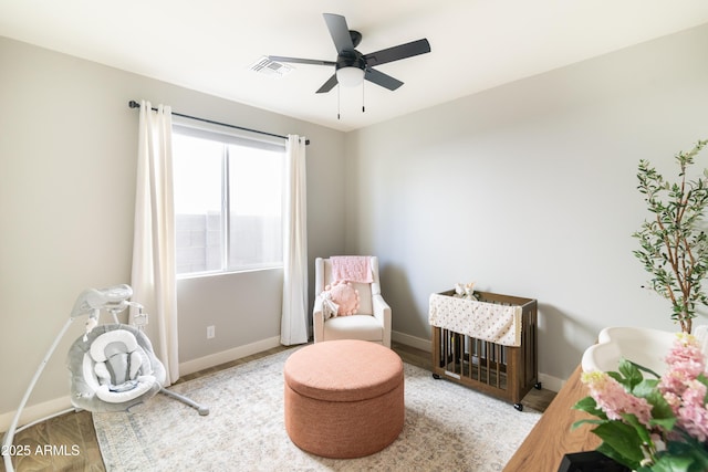 living area featuring wood-type flooring and ceiling fan