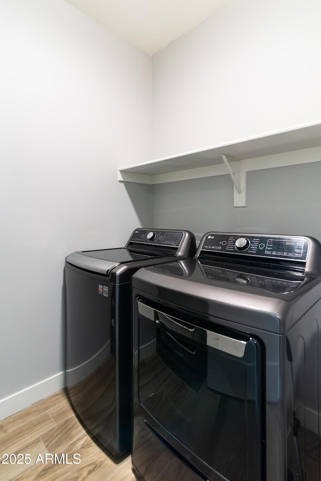 washroom with washer and clothes dryer and light hardwood / wood-style flooring