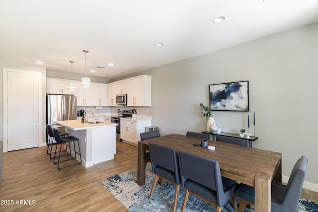 dining area featuring sink and light wood-type flooring