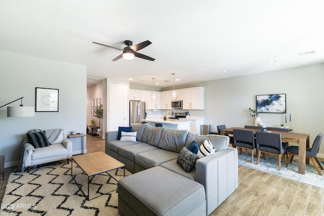 living room featuring ceiling fan and light wood-type flooring