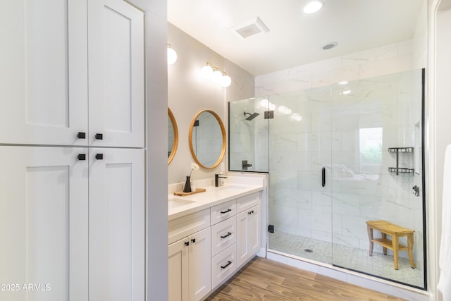 bathroom featuring hardwood / wood-style flooring, vanity, and a shower with door