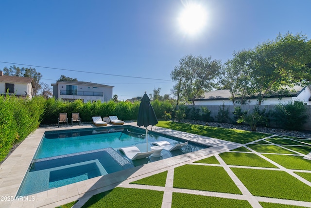 view of swimming pool featuring a lawn and an in ground hot tub