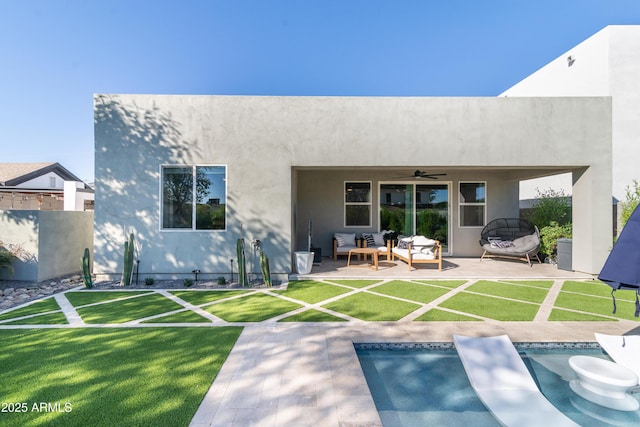 rear view of property with an outdoor living space, a yard, a patio area, and ceiling fan