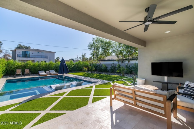 view of swimming pool with ceiling fan, a yard, a patio, an outdoor living space, and an in ground hot tub