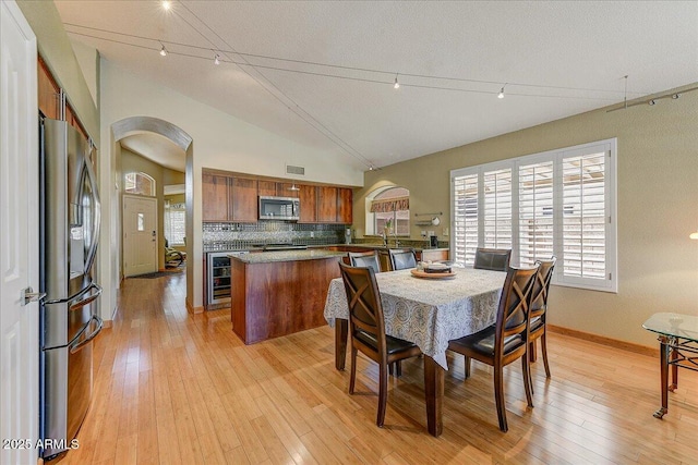 5674 W N Ln, Glendale, AZ 85302 - dining area with arched walkways, visible vents, beverage cooler, light wood finished floors, and baseboards