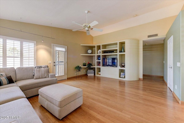 5674 W N Ln, Glendale, AZ 85302 - living room with vaulted ceiling, built in shelves, visible vents, ceiling fan, and light wood finished floors