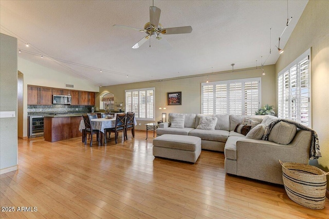 5674 W N Ln, Glendale, AZ 85302 - living room with a textured ceiling, light wood-type flooring, beverage cooler, and a ceiling fan