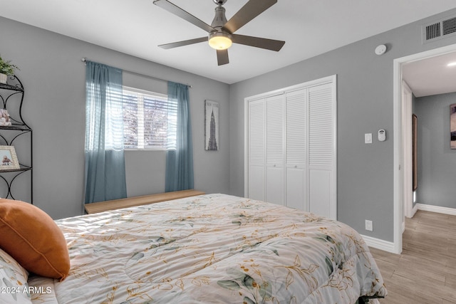 bedroom featuring light wood-type flooring, a closet, and ceiling fan