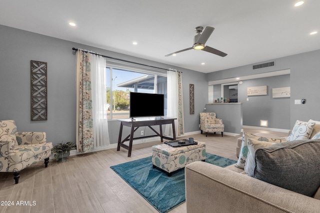 living room featuring light hardwood / wood-style flooring and ceiling fan