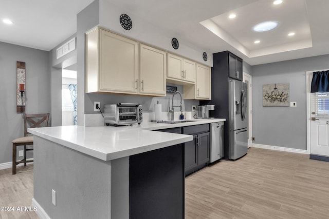 kitchen with a wealth of natural light, light wood-type flooring, sink, and appliances with stainless steel finishes