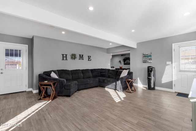 living room with beamed ceiling and light wood-type flooring