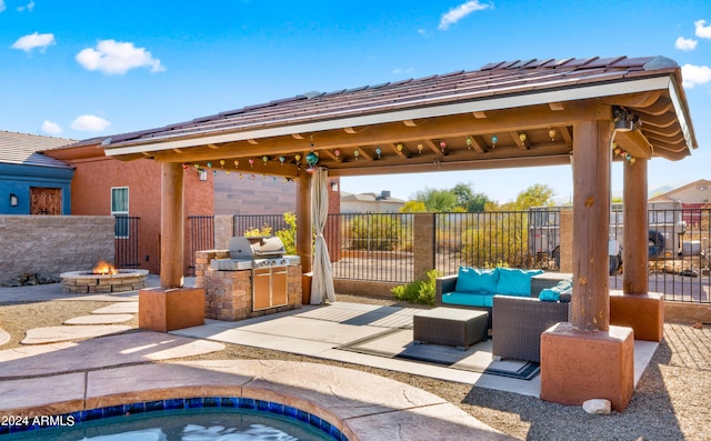 view of patio / terrace with a gazebo, an outdoor kitchen, area for grilling, and an outdoor living space with a fire pit