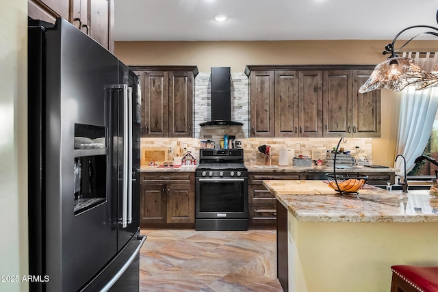 kitchen featuring stainless steel range, sink, wall chimney range hood, black refrigerator with ice dispenser, and decorative backsplash