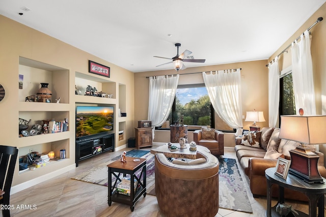 living room featuring built in shelves and ceiling fan