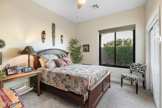 bedroom with ceiling fan, light colored carpet, and a closet