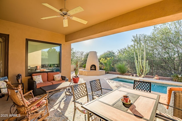 view of patio / terrace featuring a fenced in pool, ceiling fan, and an outdoor living space with a fireplace