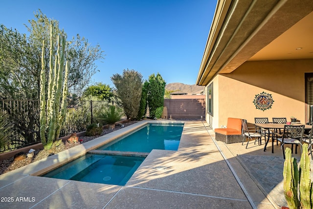 view of pool featuring a mountain view, an in ground hot tub, and a patio