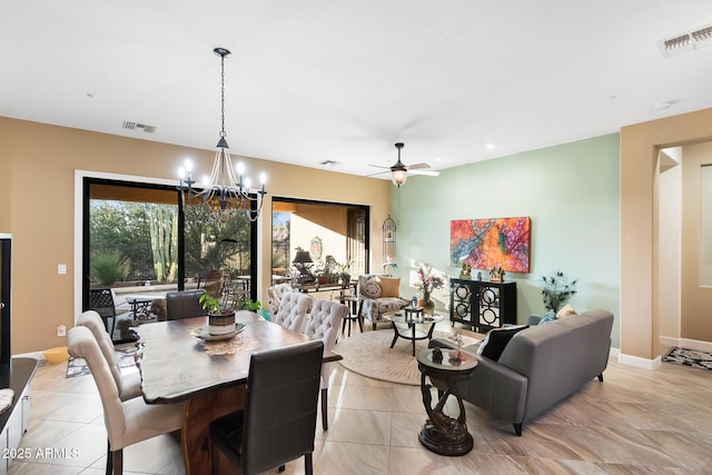 tiled dining room featuring ceiling fan with notable chandelier