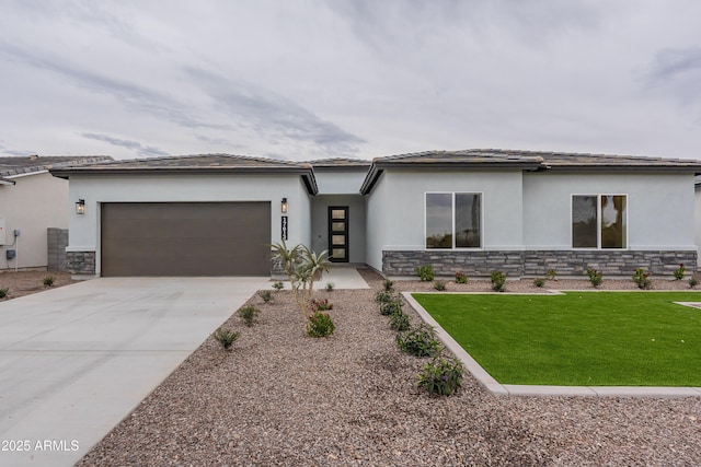 prairie-style home featuring a front lawn and a garage