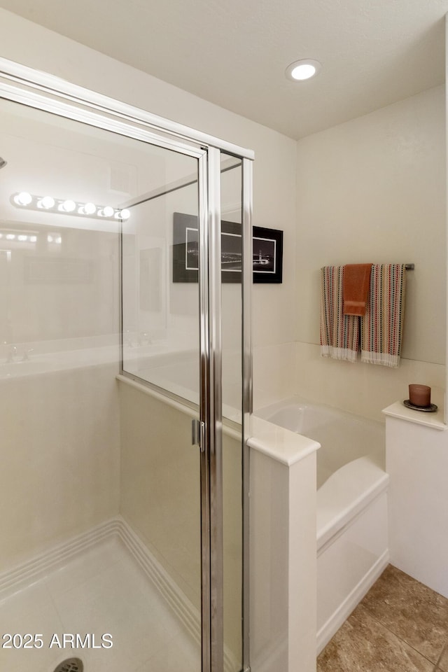 bathroom with independent shower and bath and tile patterned flooring