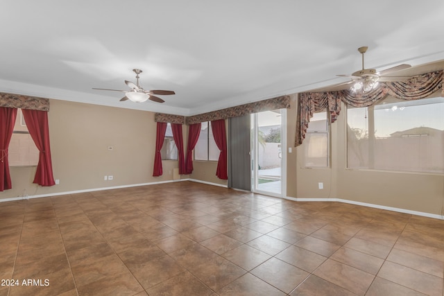 empty room featuring ceiling fan and a wealth of natural light