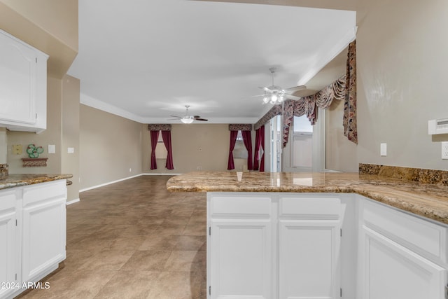 kitchen featuring ceiling fan, light stone counters, white cabinetry, and kitchen peninsula