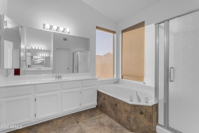 bathroom featuring vanity, vaulted ceiling, separate shower and tub, a healthy amount of sunlight, and tile patterned flooring