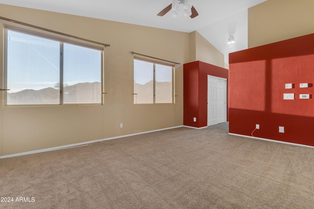 spare room featuring a mountain view, ceiling fan, light colored carpet, and vaulted ceiling