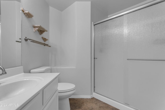 bathroom with tile patterned flooring, vanity, toilet, and a shower with door