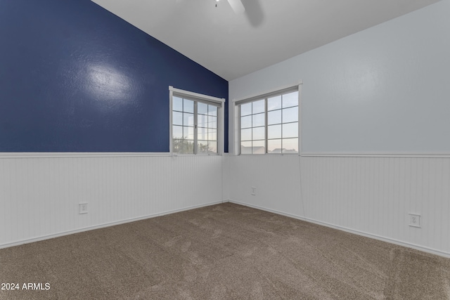 empty room featuring carpet flooring, ceiling fan, and lofted ceiling