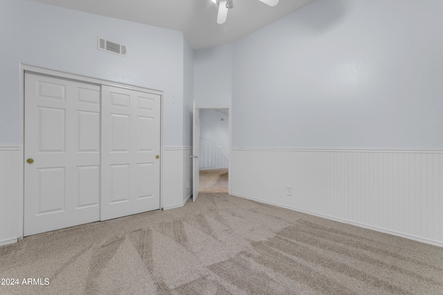 unfurnished bedroom featuring light carpet, a closet, and ceiling fan