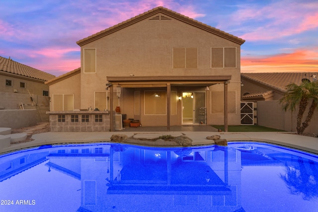 pool at dusk with a patio