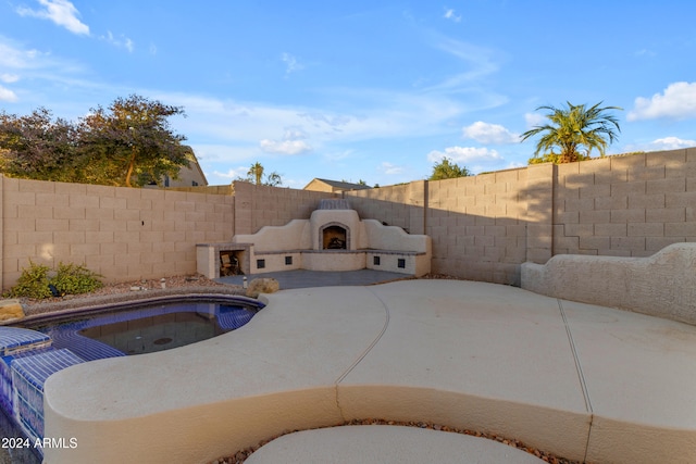 view of pool featuring a patio area, an outdoor fireplace, and a hot tub