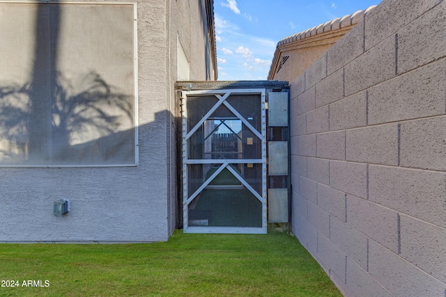 view of exterior entry with a lawn