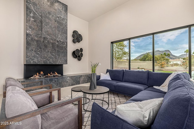 living room with lofted ceiling, a mountain view, and a fireplace