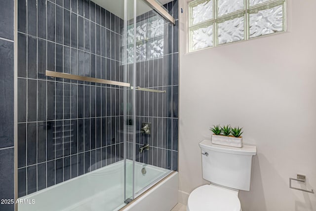 bathroom with bath / shower combo with glass door and toilet