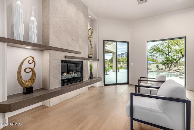 living room featuring a tiled fireplace and hardwood / wood-style floors