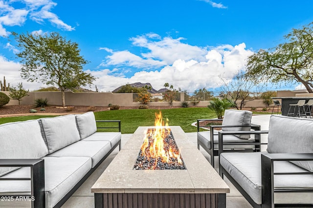 view of patio with an outdoor living space with a fire pit