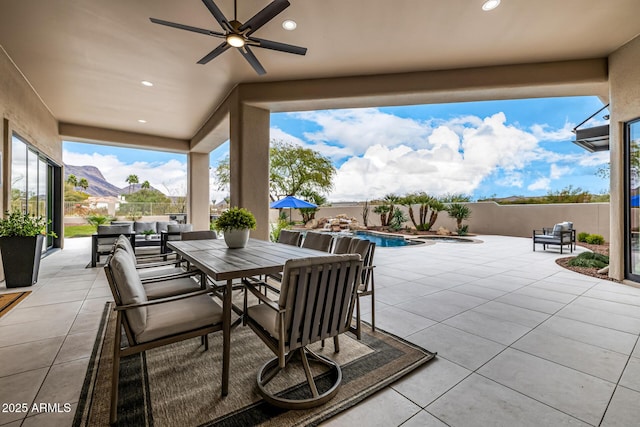 view of patio / terrace featuring ceiling fan, a fenced in pool, and a mountain view