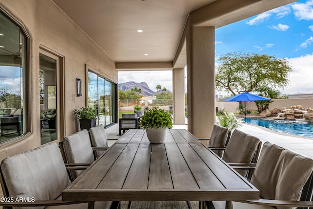 view of patio / terrace featuring a fenced in pool, pool water feature, and a mountain view