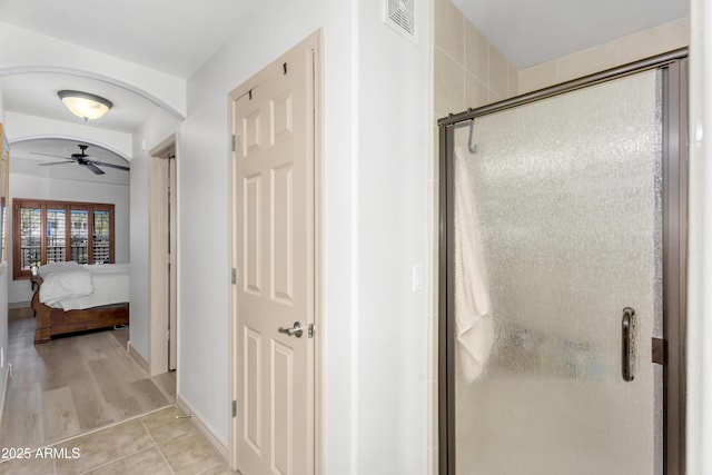 full bath with visible vents, a stall shower, ensuite bathroom, tile patterned flooring, and ceiling fan